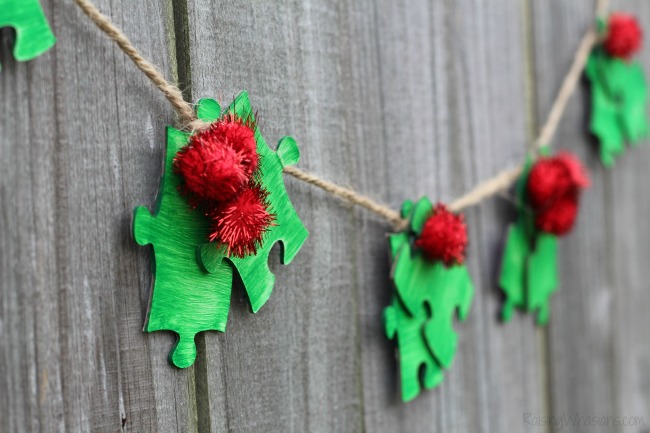 Upcycled puzzle piece Christmas craft Puzzle Piece Holly Garland Christmas Kids Craft | make this easy upcycled kids craft for the holidays using old puzzle pieces! #Christmas #Craft #KidsCraft